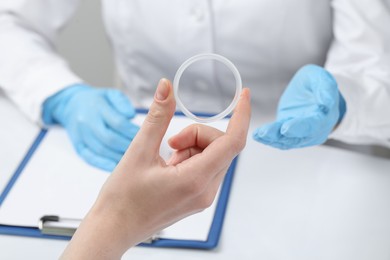 Photo of Woman holding diaphragm vaginal contraceptive ring at the doctor's appointment, closeup
