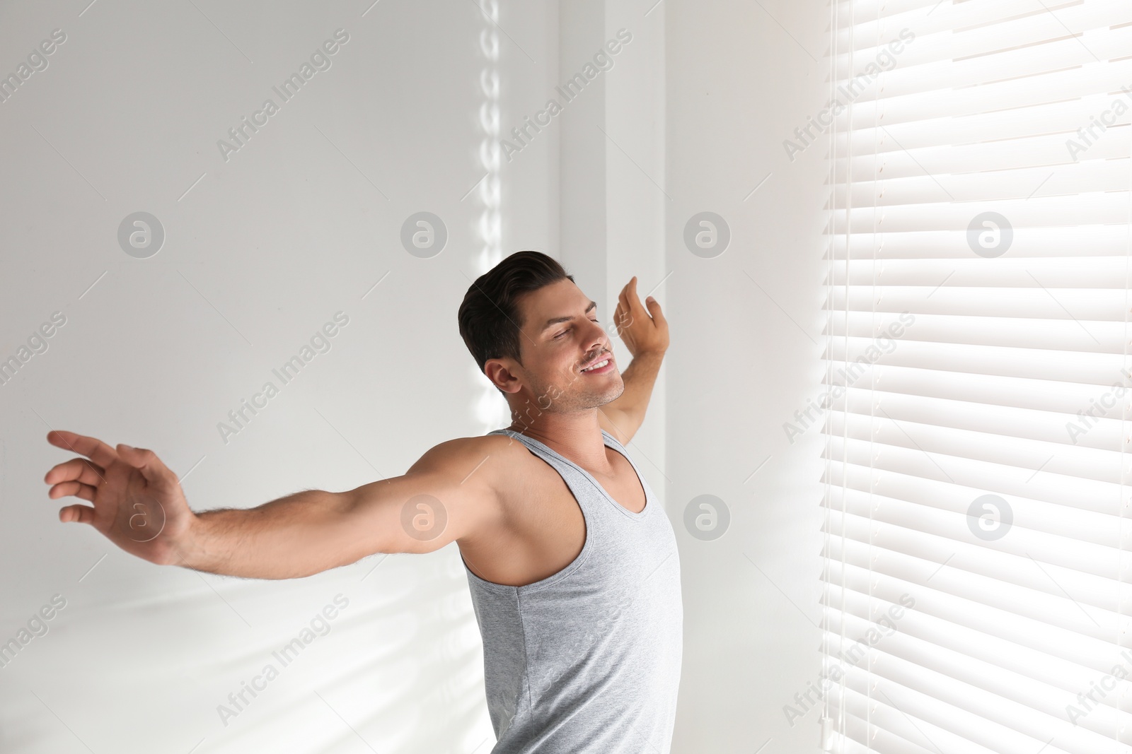 Photo of Man near window in bedroom. Lazy morning