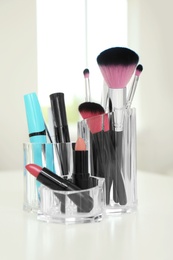 Photo of Organizer with cosmetic products for makeup on table indoors