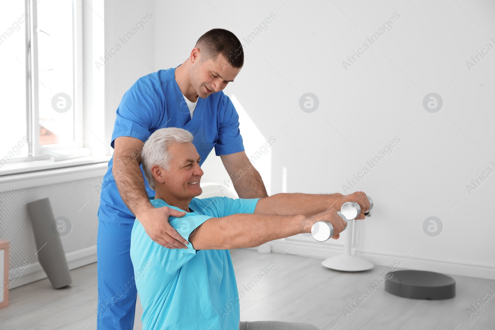 Photo of Professional physiotherapist working with senior patient in rehabilitation center