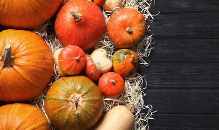 Photo of Flat lay composition with different pumpkins and space for text on wooden background. Autumn holidays