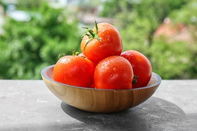 Photo of Plate with fresh ripe tomatoes on table outdoors