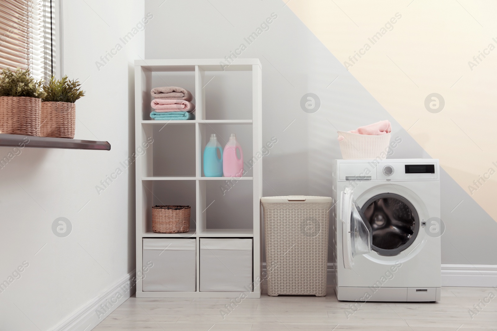 Photo of Modern washing machine in laundry room interior