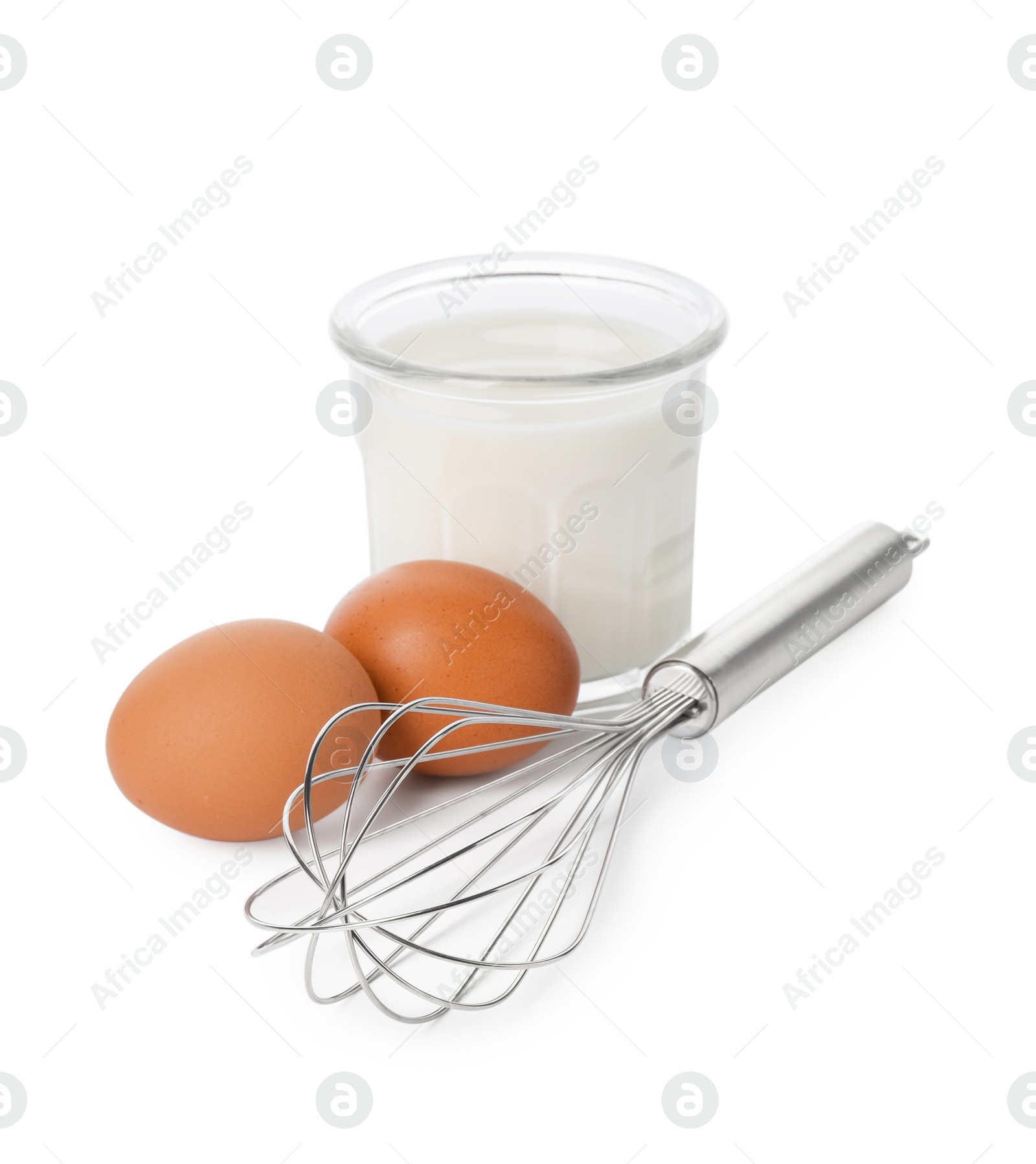 Photo of Metal whisk, raw eggs and glass of milk isolated on white