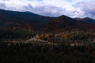 Image of Aerial view of mountain forest and village on autumn day