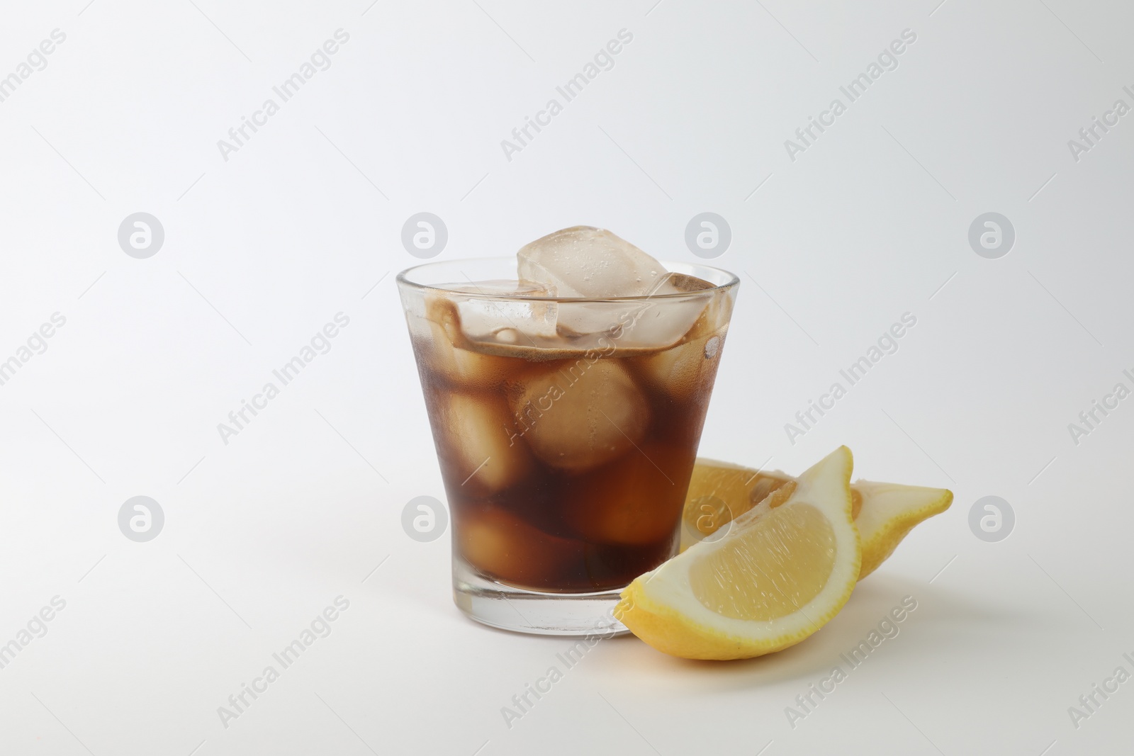 Photo of Iced coffee in glass and cut lemon on white background