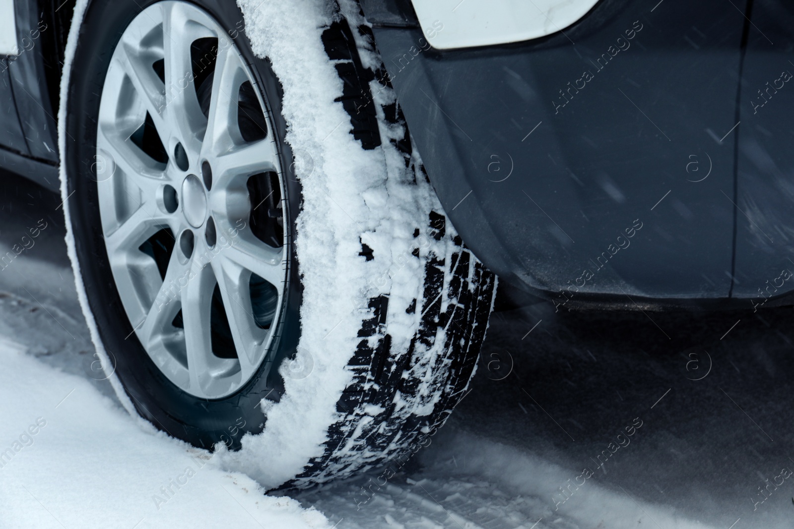 Photo of Modern car on snowy road, closeup view. Winter season