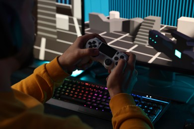 Man playing video games with controller at table indoors, closeup