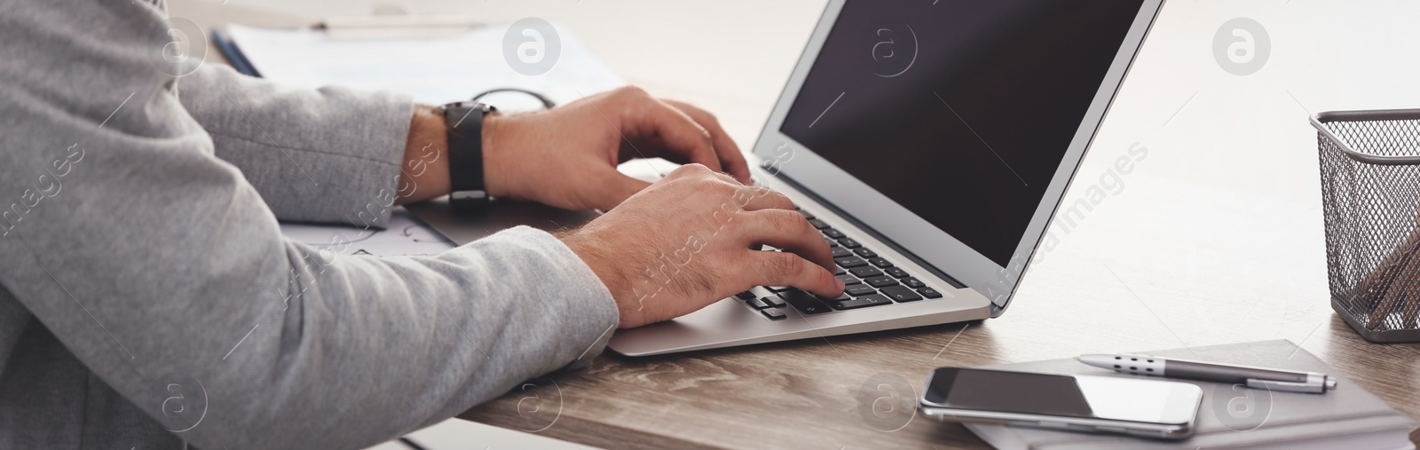 Image of Young man working on computer at table indoors, closeup. Banner design