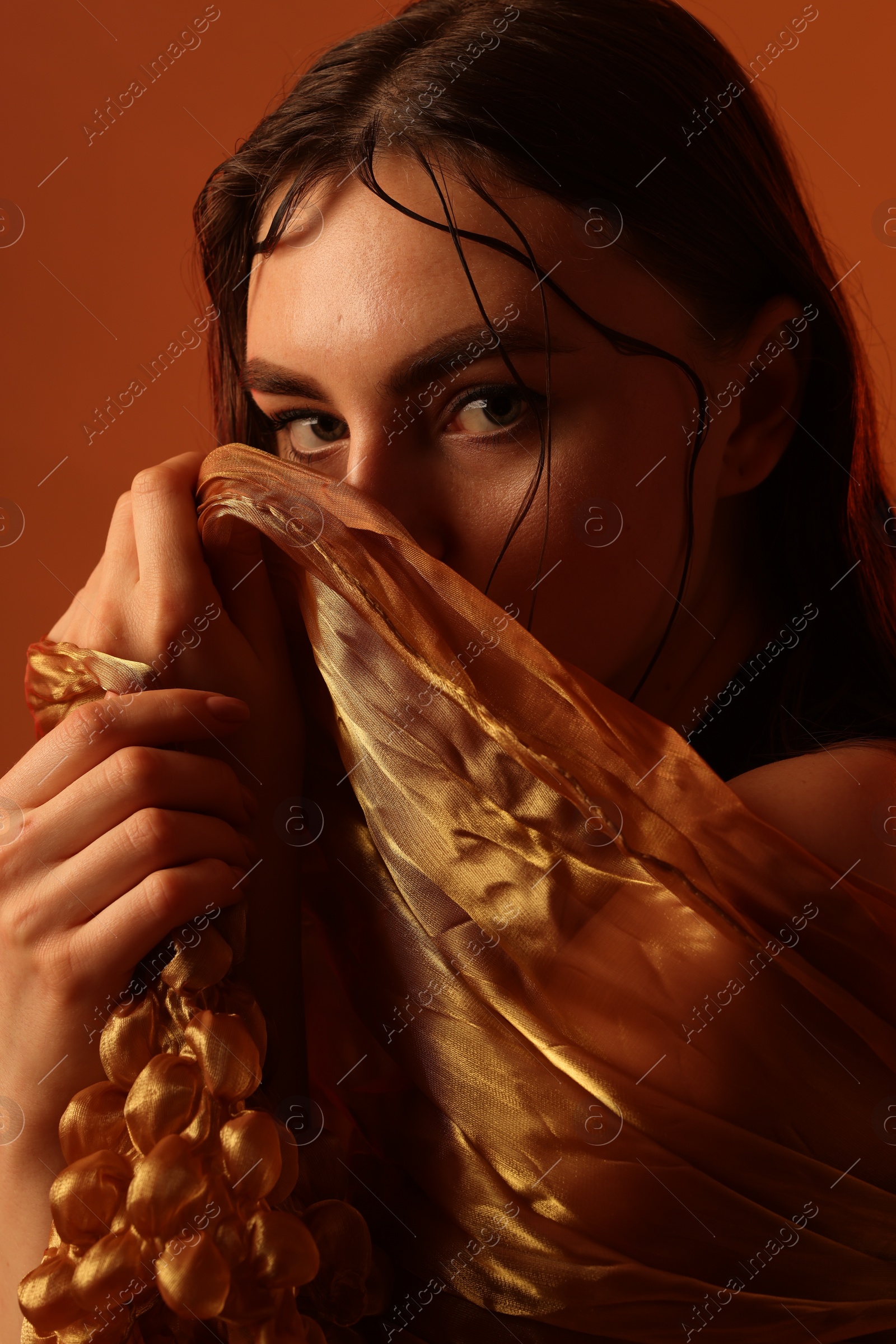 Photo of Fashionable portrait of beautiful woman on brown background, closeup