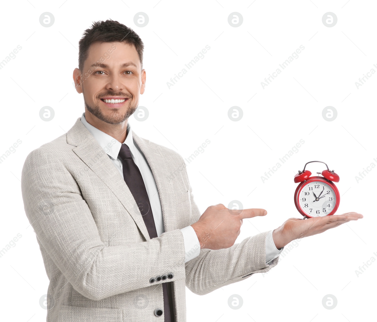 Photo of Happy businessman pointing on alarm clock against white background. Time management