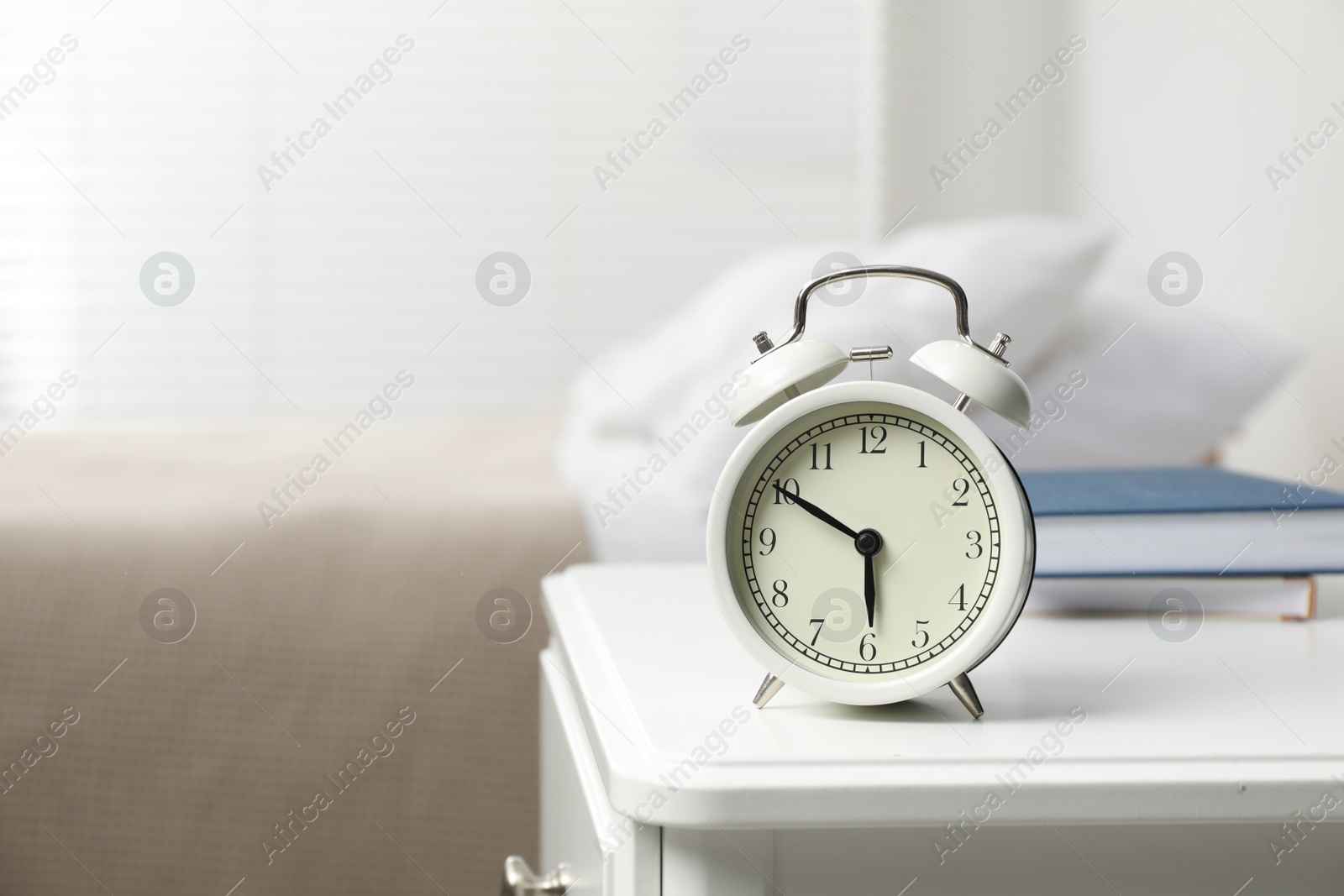 Photo of Alarm clock on white nightstand in bedroom, space for text