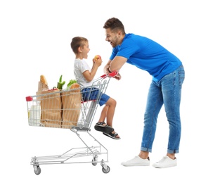 Father and son with full shopping cart on white background