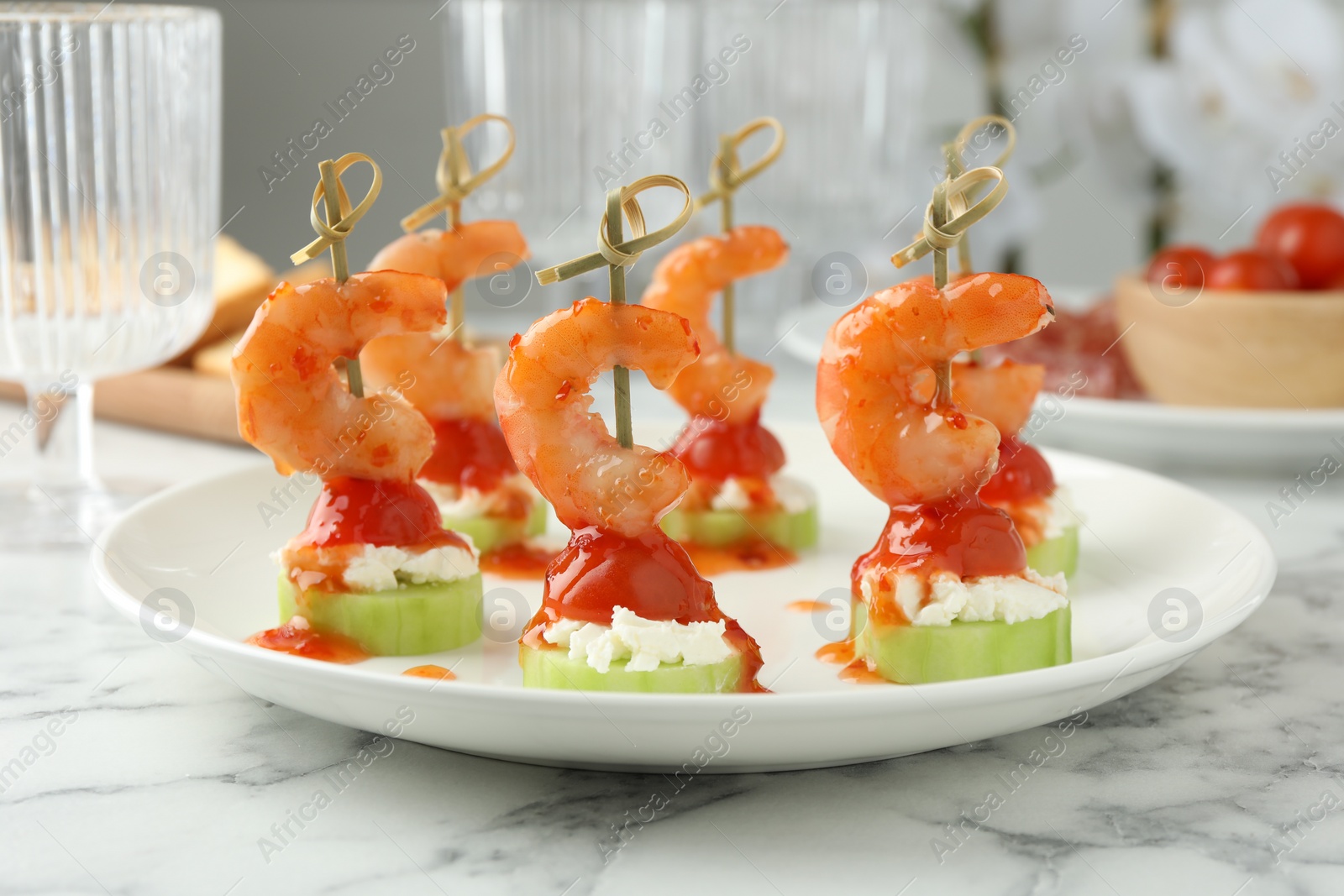 Photo of Tasty canapes with shrimps, vegetables and cream cheese on white marble table