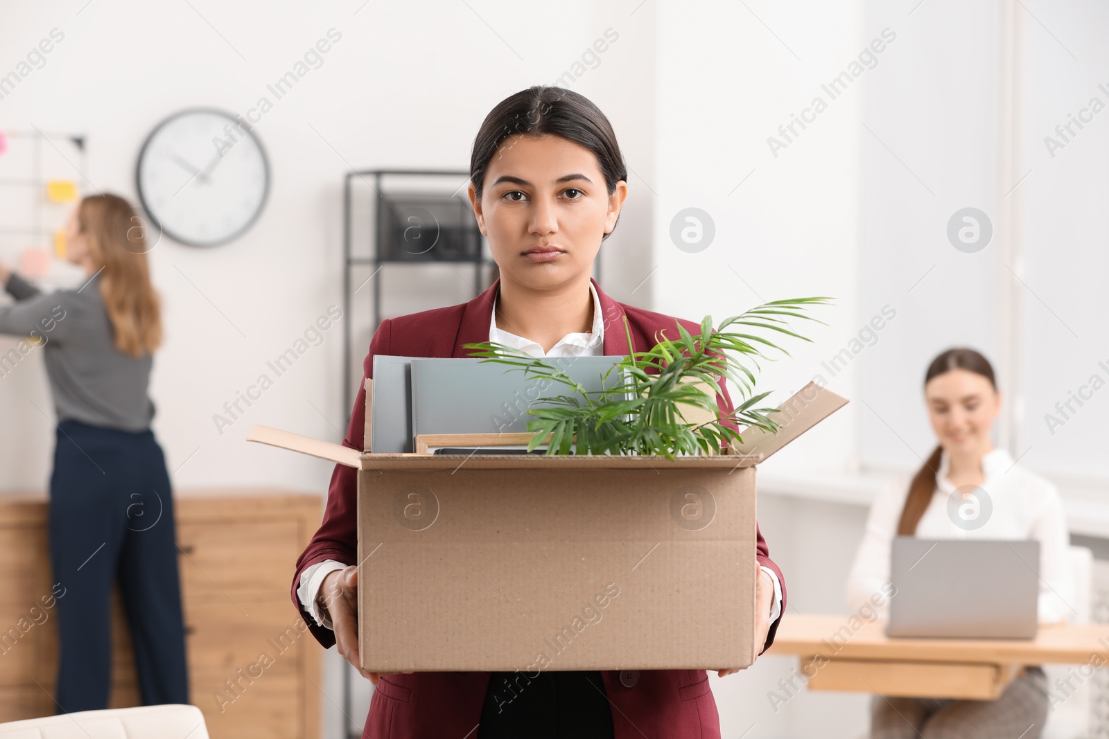 Photo of Unemployment problem. Woman with box of personal belongings in office