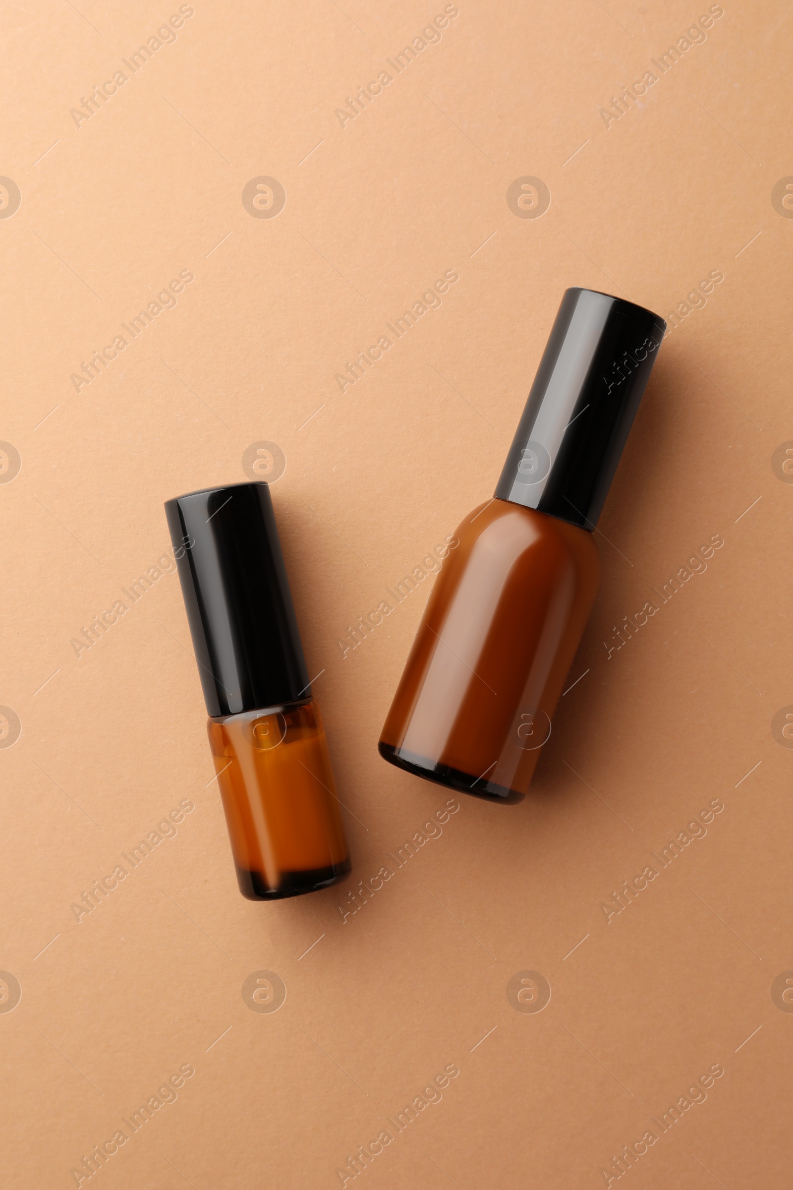 Photo of Bottles of face cream on beige background, flat lay