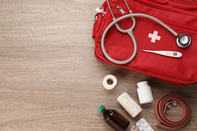Photo of First aid kit on wooden table, flat lay. Space for text