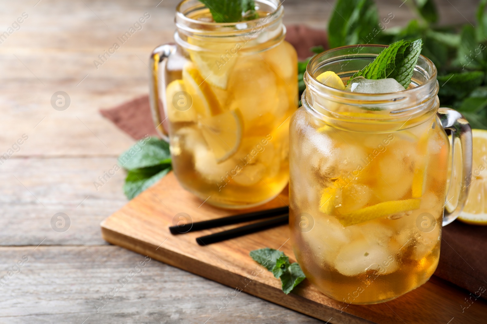 Photo of Delicious iced tea on wooden table, space for text