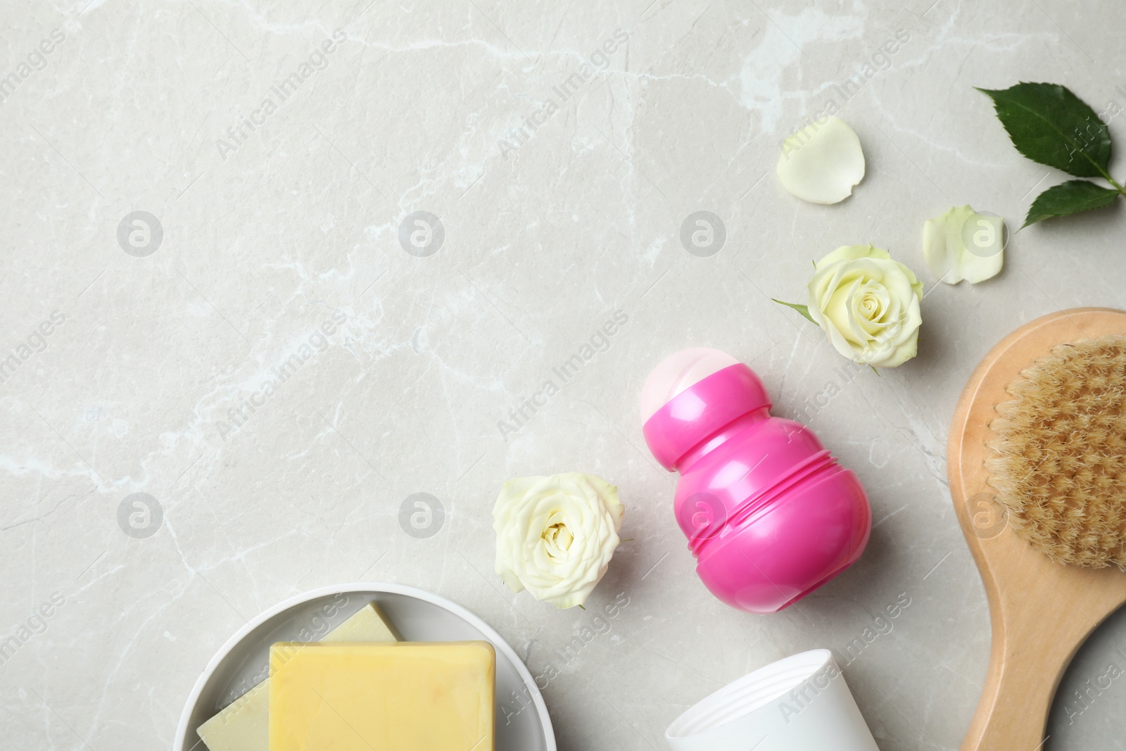 Photo of Flat lay composition with natural deodorant and bath accessories on light grey marble table. Space for text