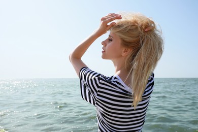 Photo of Beautiful young woman near sea on sunny day in summer