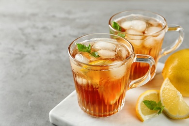 Photo of Cups of refreshing iced tea on light table