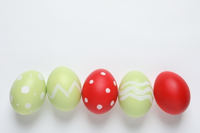 Photo of Flat lay composition of painted Easter eggs on white background