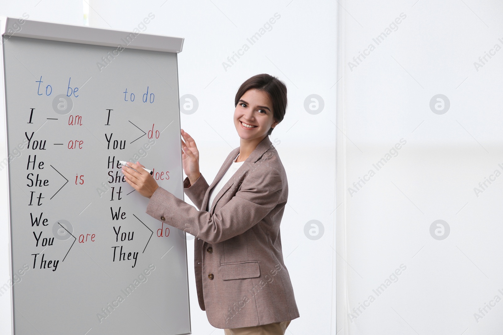 Photo of English teacher near whiteboard in class at lesson