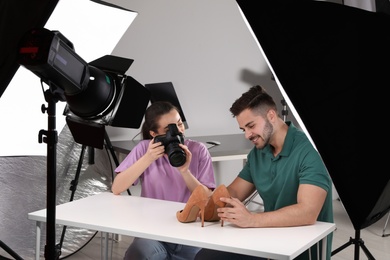 Professional photographers shooting stylish shoes in studio