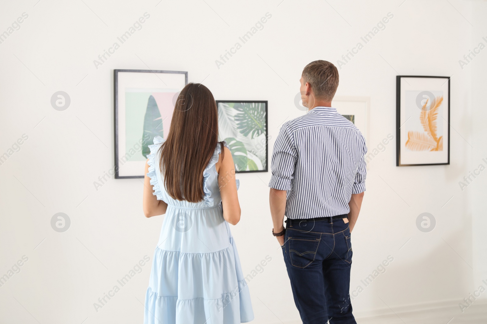 Photo of Young couple at exhibition in art gallery