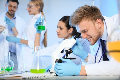 Group of scientists working in modern chemistry laboratory