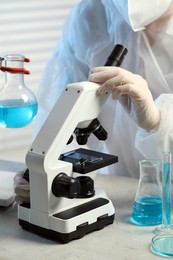 Photo of Scientist working with microscope in laboratory, closeup