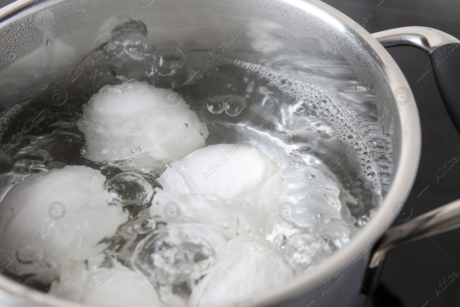 Photo of Chicken eggs boiling in pot, closeup view