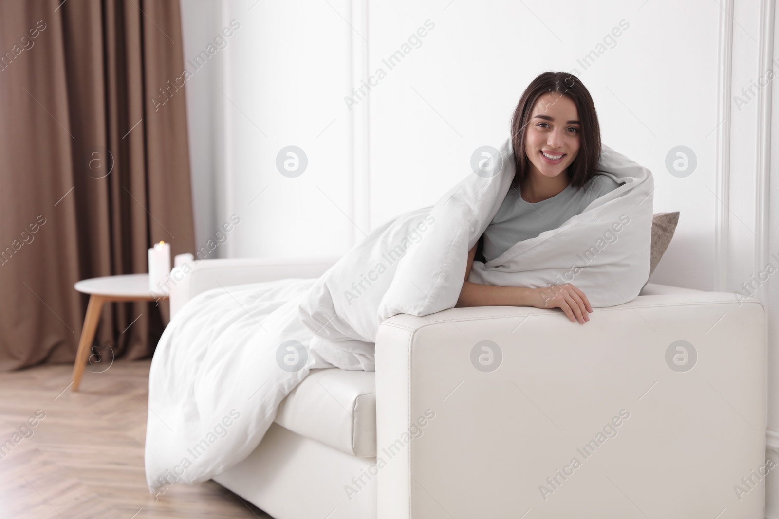 Photo of Woman covered in blanket resting on sofa, space for text