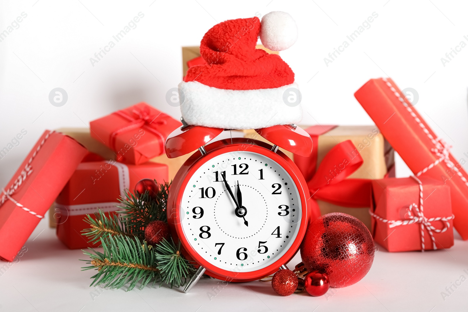 Photo of Alarm clock with Christmas decor on white background. New Year countdown