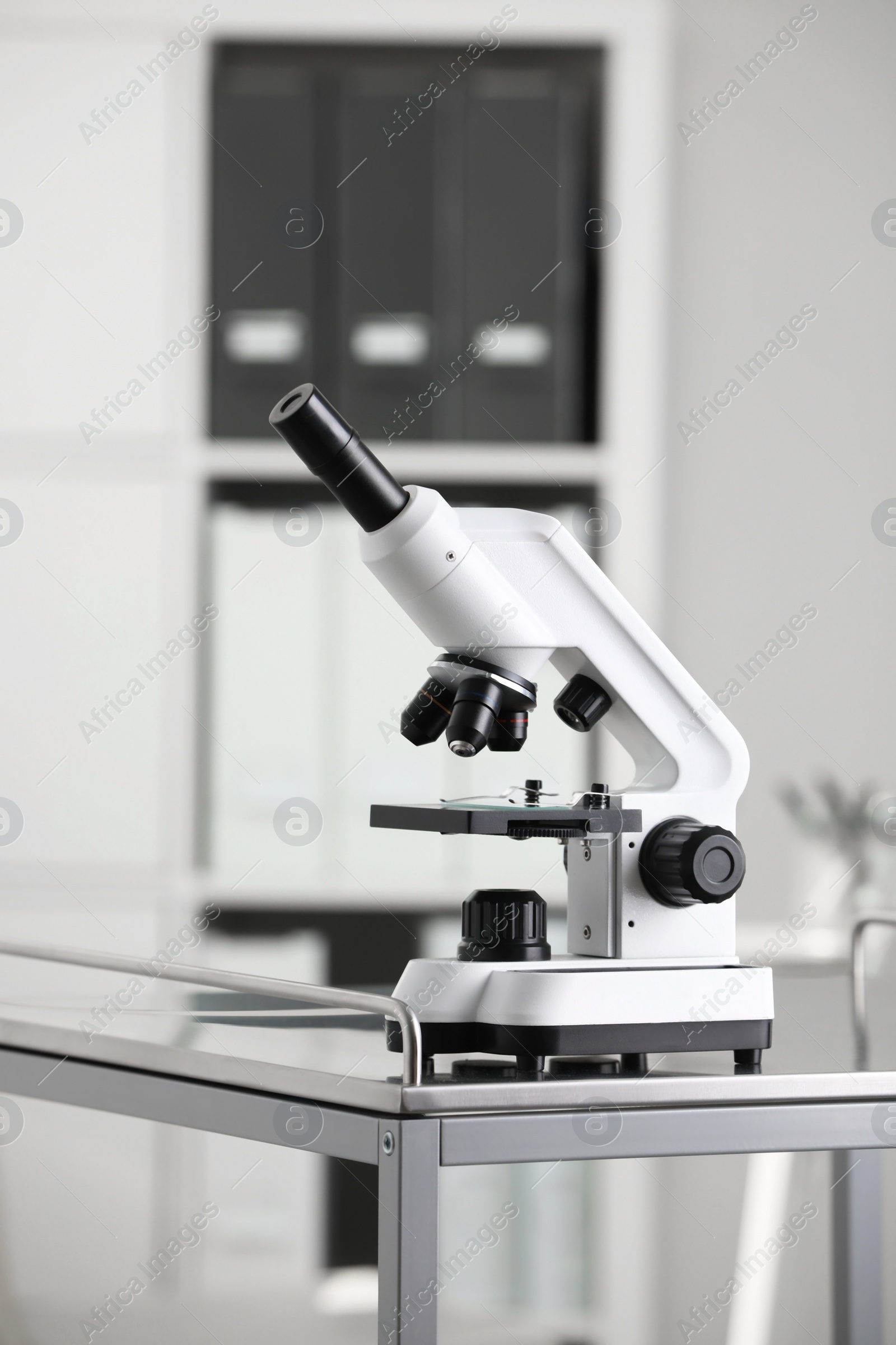 Photo of Modern medical microscope on metal table in laboratory