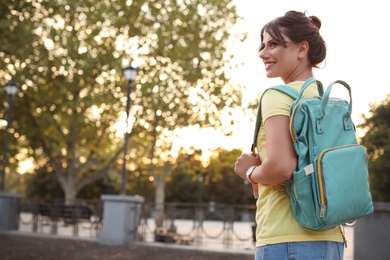 Young woman with stylish turquoise bag outdoors