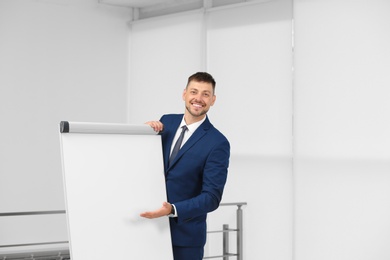 Professional business trainer near flip chart board indoors. Space for text