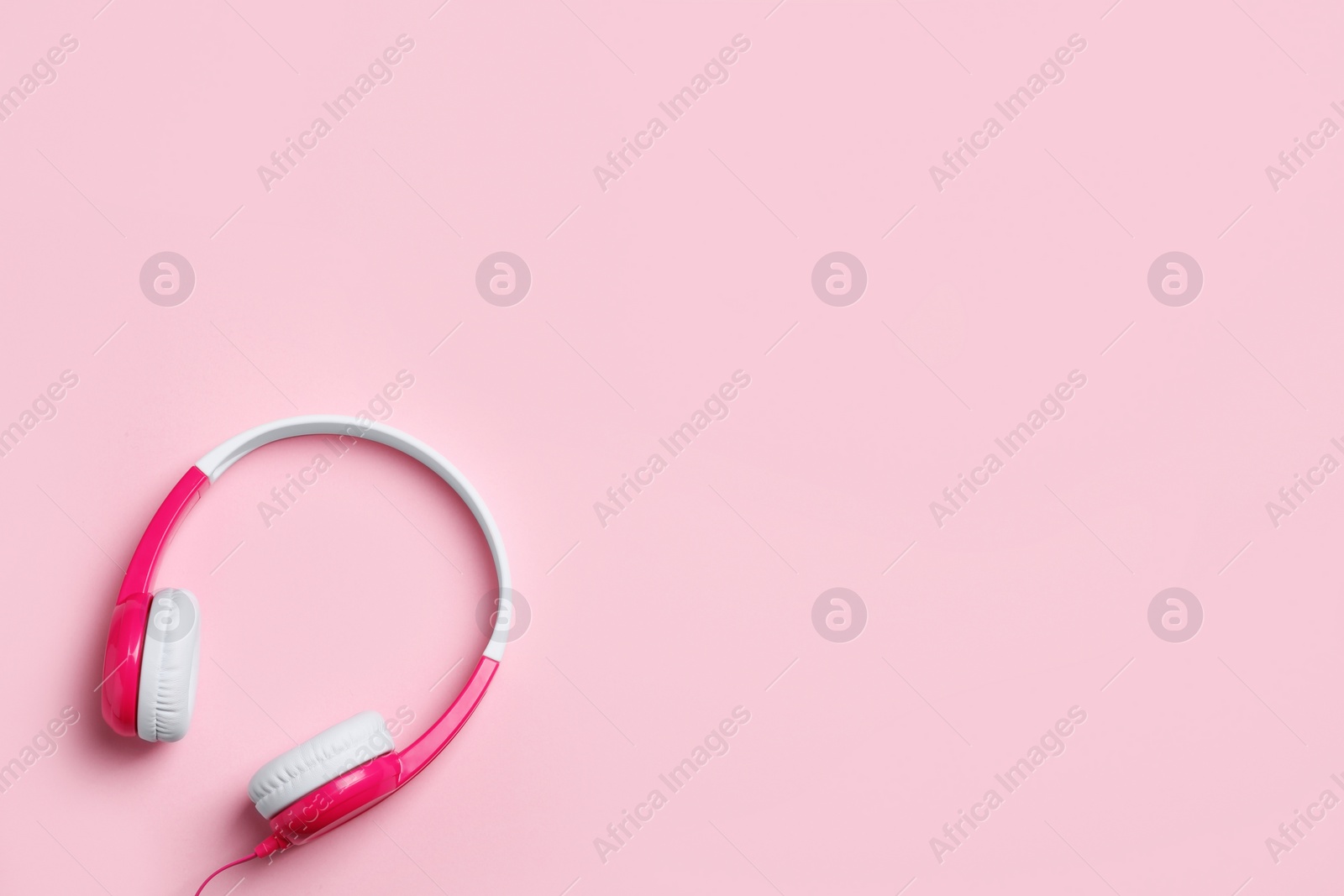 Photo of Stylish headphones on color background, top view. Space for text