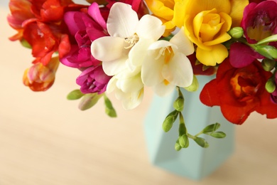 Photo of Beautiful spring bright freesia flowers on table, closeup. Space for text