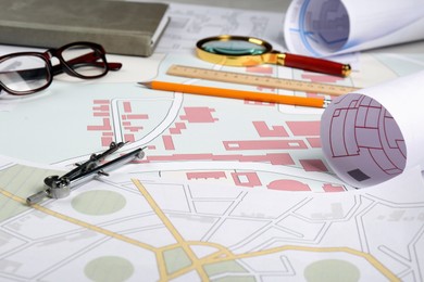 Office stationery and eyeglasses on cadastral maps of territory with buildings