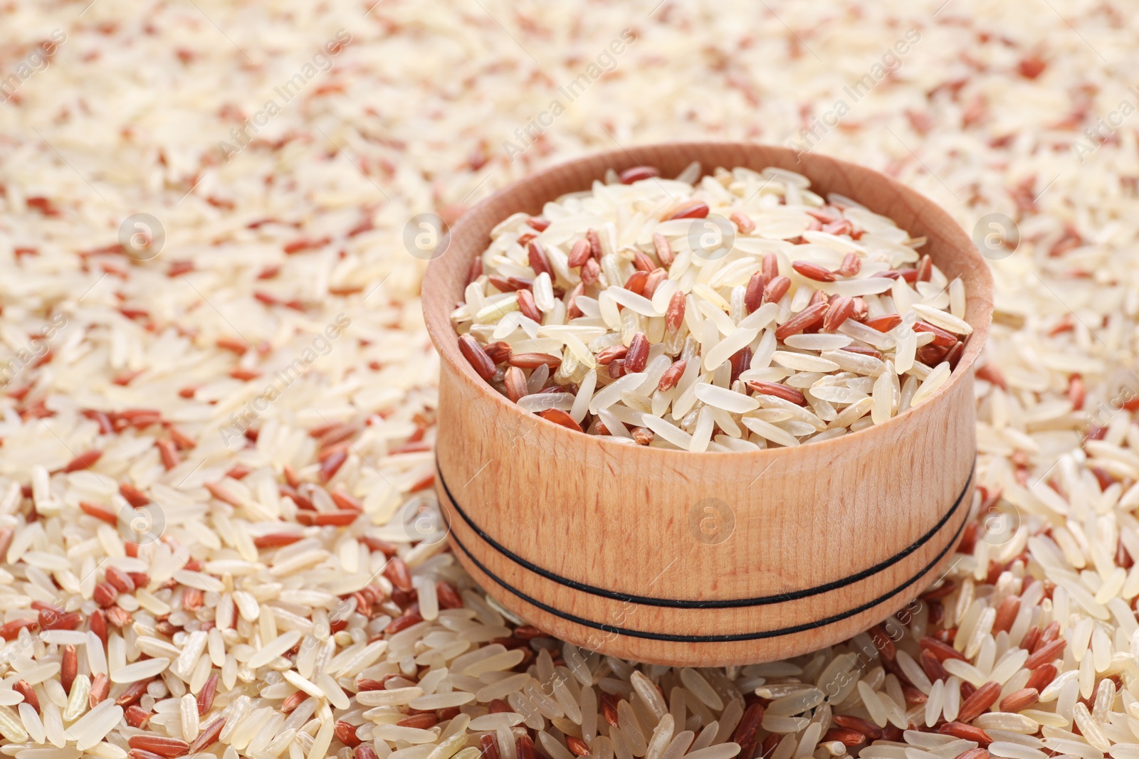 Photo of Mix of brown and polished rice with bowl, closeup