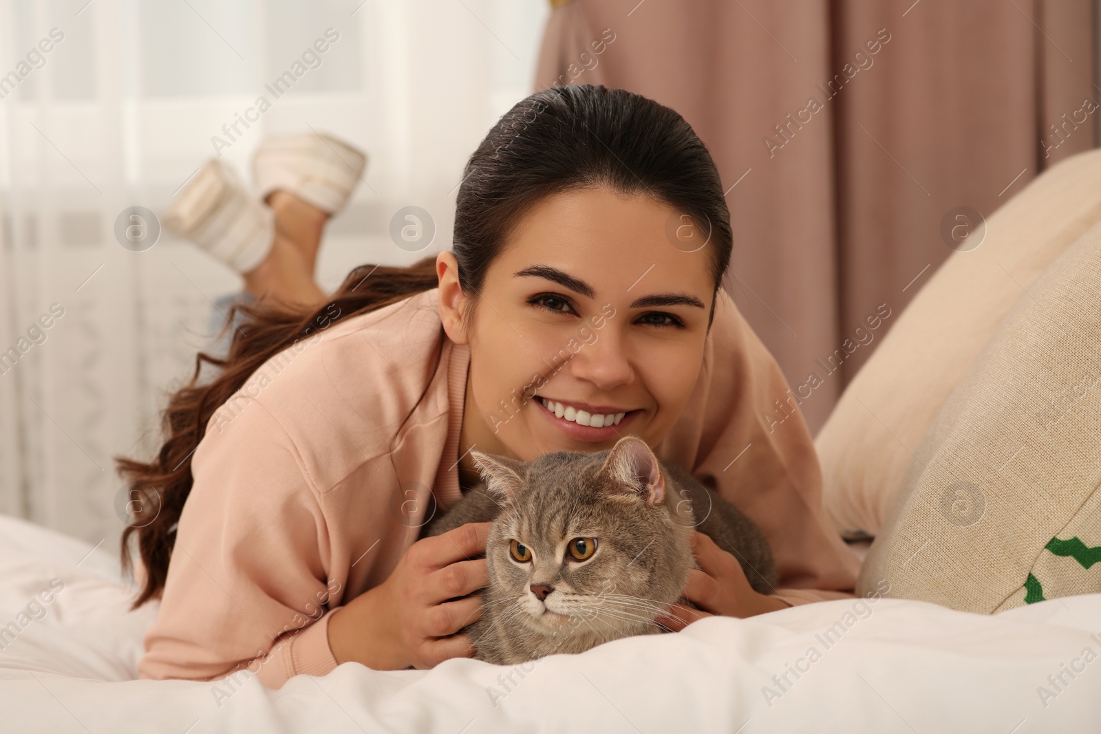 Photo of Young woman with adorable cat at home