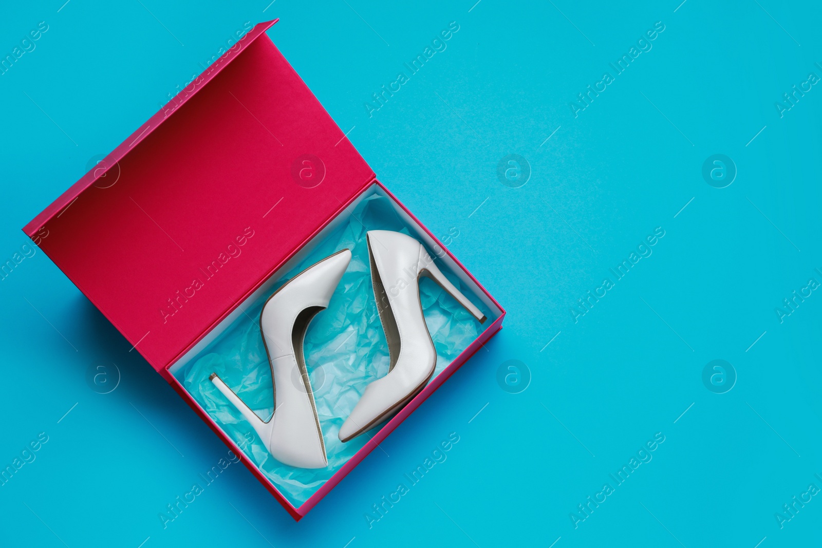 Photo of Stylish women's shoes in cardboard box on light blue background, top view. Space for text