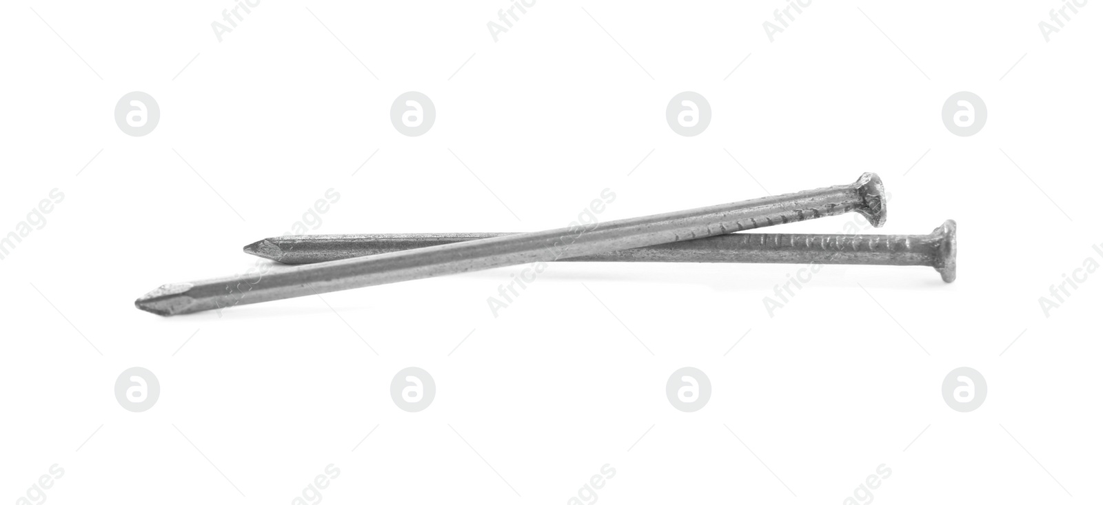 Photo of Sharp shiny metal nails on white background