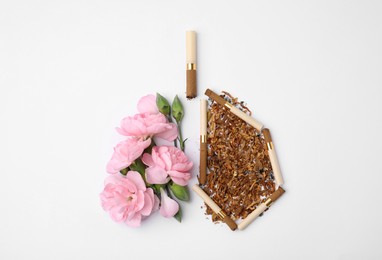 Photo of No smoking concept. Lungs made of dry tobacco, cigarettes and pink flowers on white background, flat lay