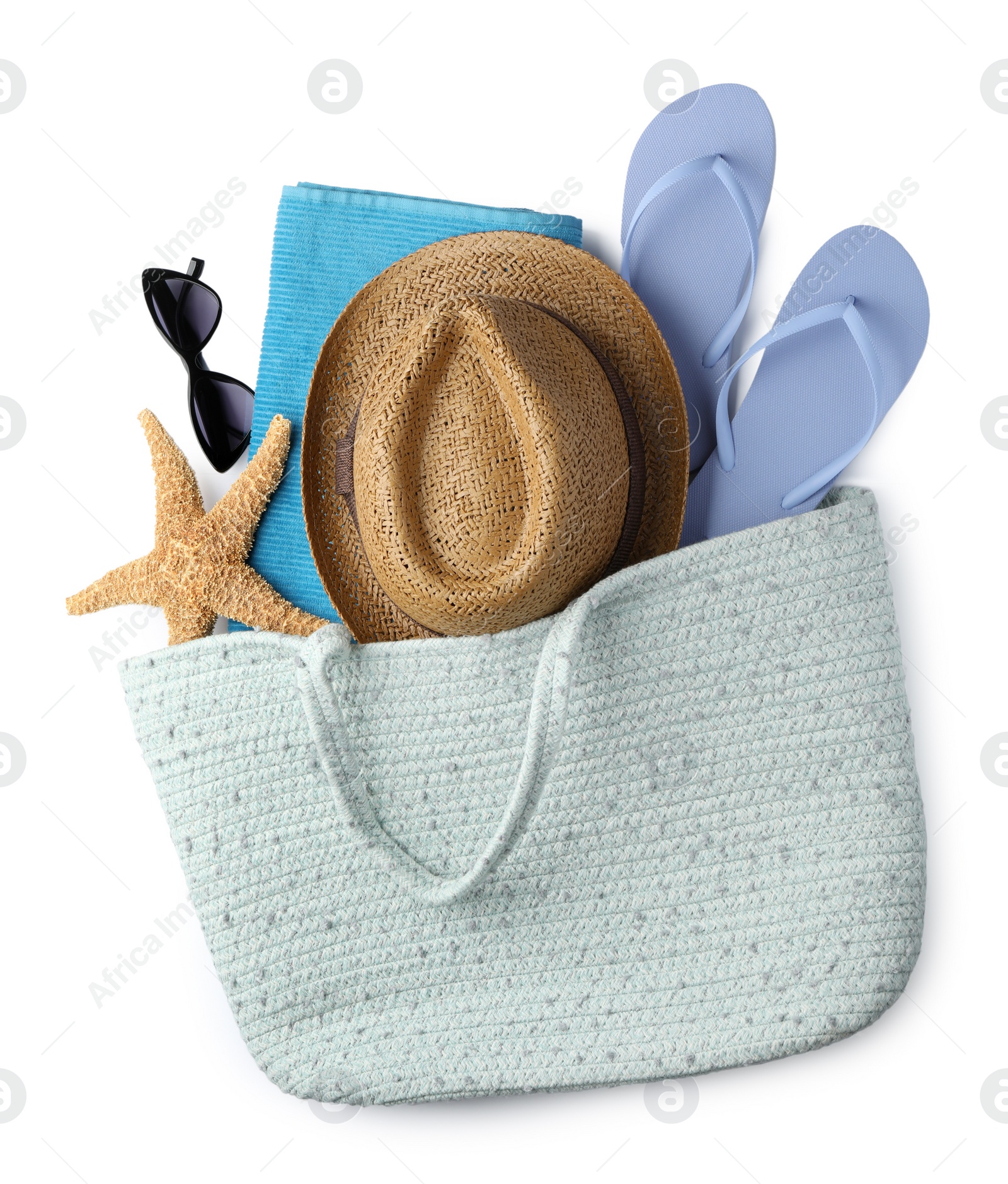 Photo of Stylish bag with different beach accessories on white background, top view