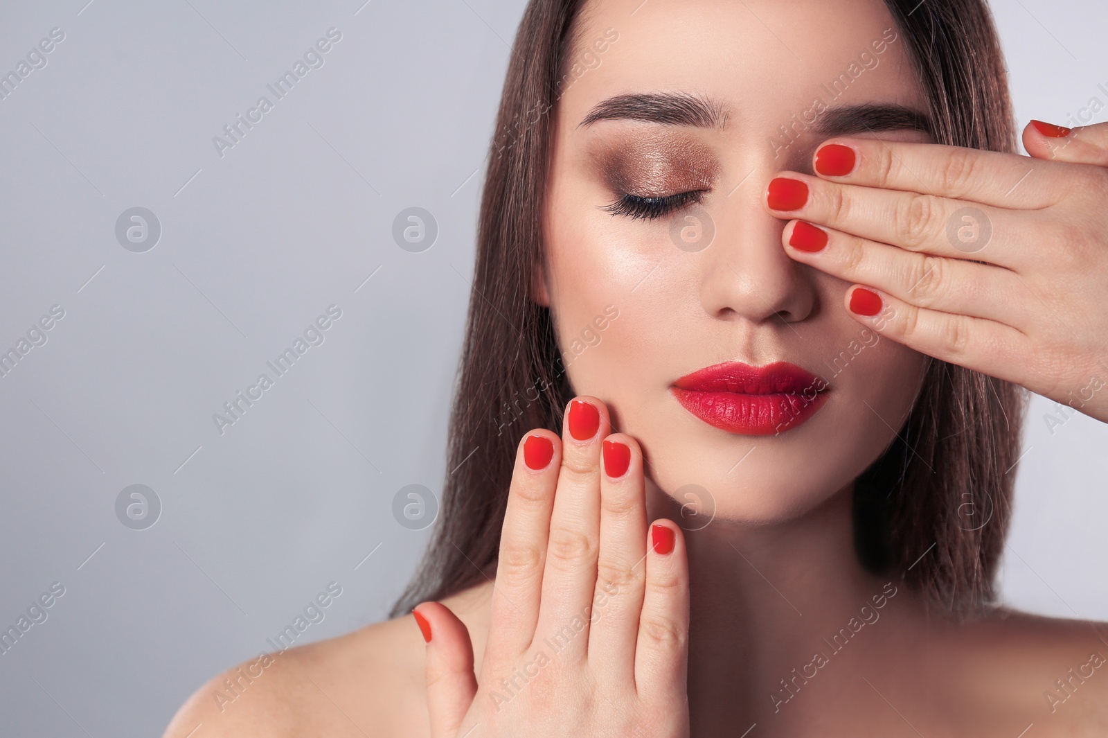 Photo of Beautiful woman with stylish nail polish on grey background, space for text