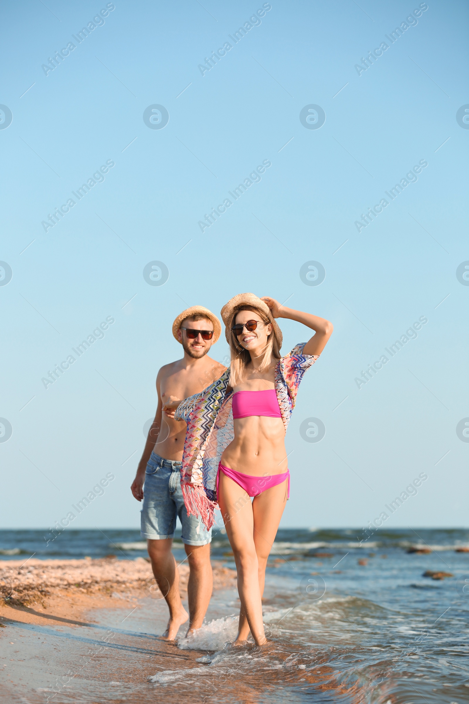 Photo of Young couple spending time together on beach