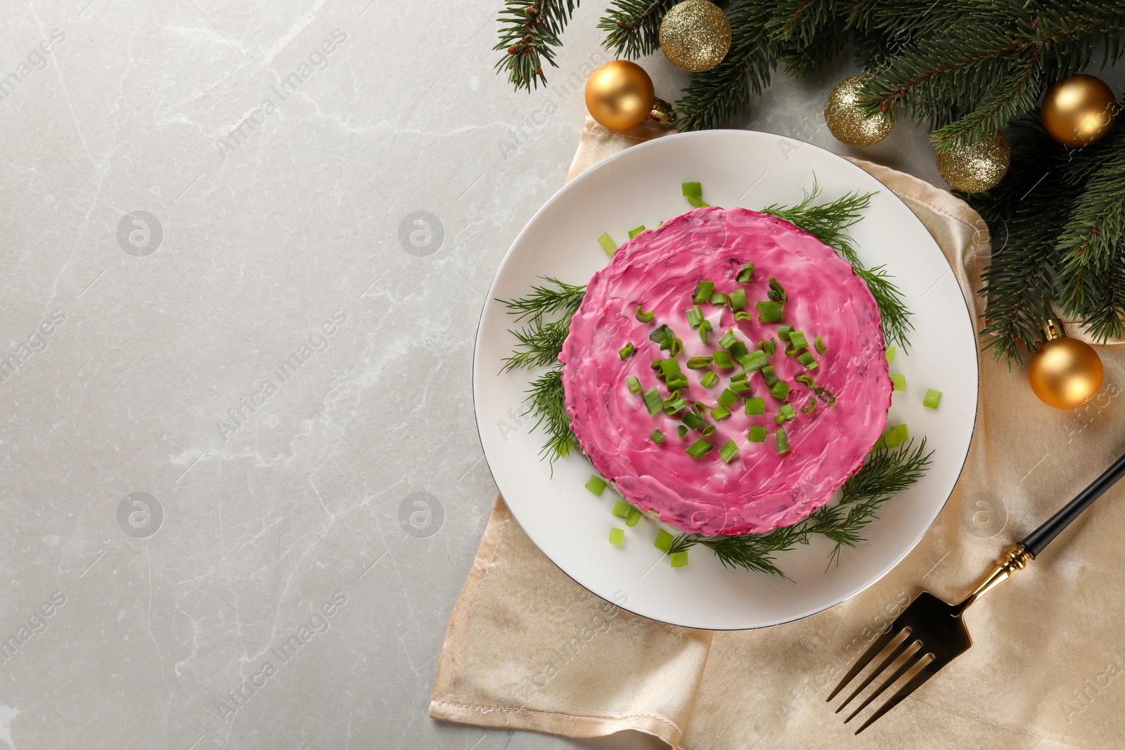 Photo of Herring under fur coat salad and Christmas decor on light grey table, flat lay with space for text. Traditional Russian dish