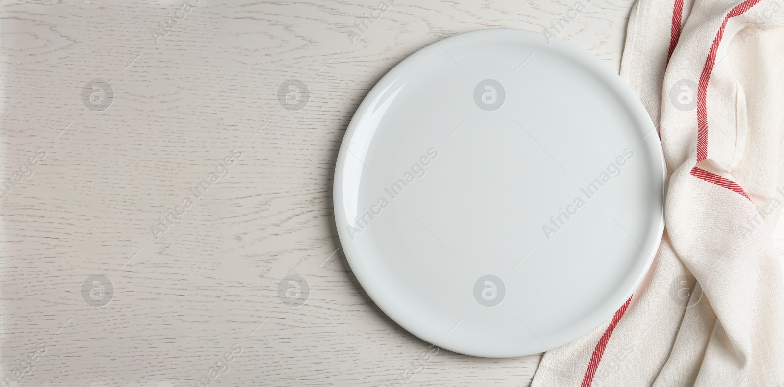 Photo of Empty plate and fabric on white wooden table, flat lay